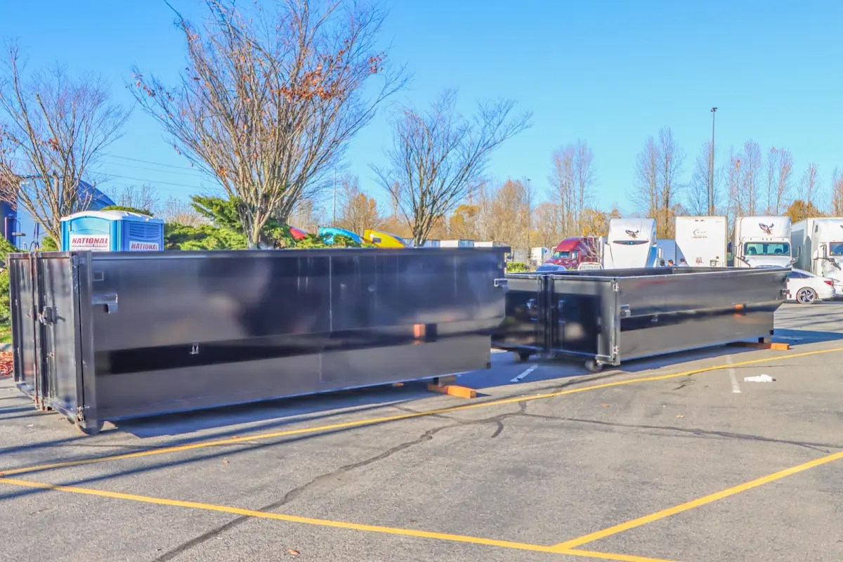 Professional dumpster rental service with roll-off container on residential driveway in Walnut Park